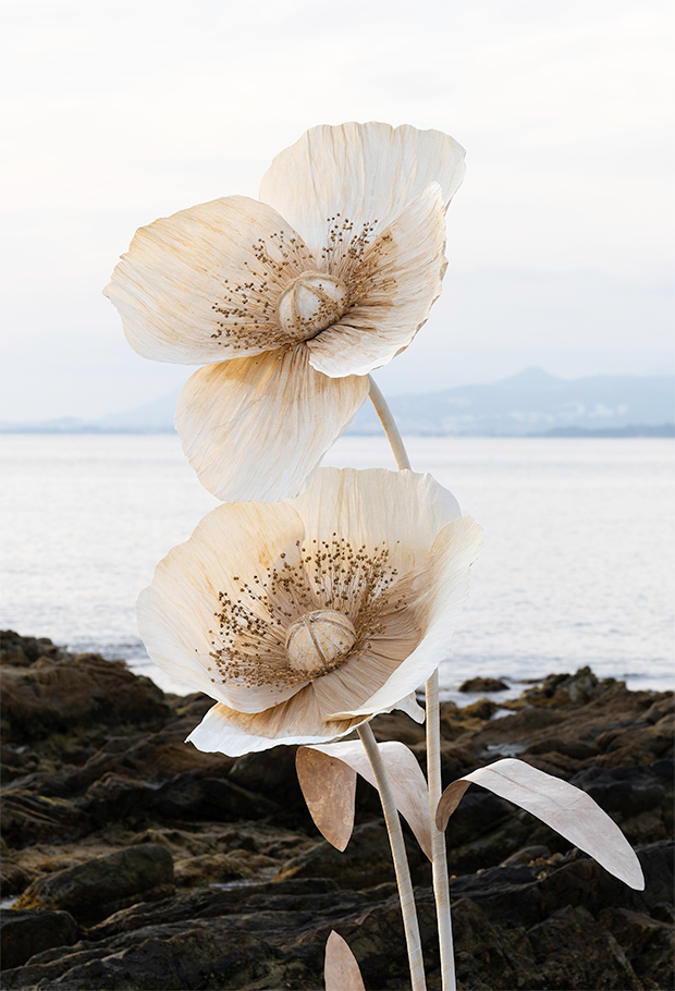 Duo de fleurs en papier géantes blanches et beiges au bord de mer. création artisanale Étoile Vagabonde