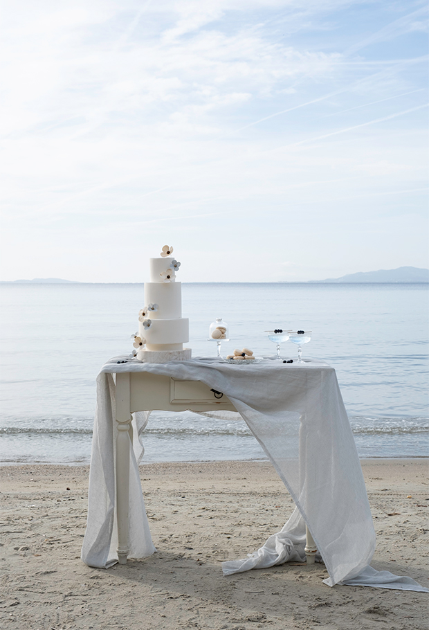Table drapée pour sucreries gateau blanc trois étages fleurs papier blanches et bleu par Étoile Vagabonde
